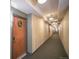 Building hallway featuring carpeted floors, decorative wall paneling, and entry door at 13456 Via Varra # 225, Broomfield, CO 80020