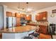 Kitchen features stainless steel appliances, breakfast bar, cherry cabinets, and hardwood floors at 13456 Via Varra # 225, Broomfield, CO 80020