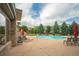 Community pool area with lounge chairs, tall pine trees, and a view of the surrounding apartments at 13456 Via Varra # 225, Broomfield, CO 80020