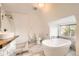 Bright bathroom features a soaking tub, herringbone tile flooring, and modern fixtures at 3521 Osage St, Denver, CO 80211
