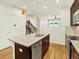 Well-designed kitchen featuring dark cabinets, a central island, stainless steel appliances, and stylish pendant lighting at 5822 S Van Gordon Ln, Littleton, CO 80127