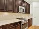 Modern kitchen showcases dark cabinetry, stainless steel appliances, light countertops, and hardwood flooring at 5822 S Van Gordon Ln, Littleton, CO 80127