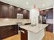 Well-lit kitchen features dark cabinetry, stainless steel appliances, a stylish island, and hardwood floors at 5822 S Van Gordon Ln, Littleton, CO 80127