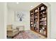 Cozy home office features a bookshelf, wood floors, a colorful rug, and a comfortable chair at 5822 S Van Gordon Ln, Littleton, CO 80127