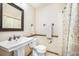 Well-lit bathroom featuring a pedestal sink, decorative mirror, and patterned shower curtain at 510 Silhouette Way, Monument, CO 80132