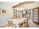 Spacious dining room featuring wood beams, light hardwood floors, and French doors at 510 Silhouette Way, Monument, CO 80132