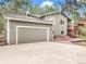 Charming gray two-story home with a two-car garage and a red staircase leading to the front deck at 510 Silhouette Way, Monument, CO 80132