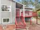 Two-story house with gray siding, red doors, and a wooden staircase leading to the entrance at 510 Silhouette Way, Monument, CO 80132
