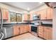 Eat-in kitchen with stainless steel appliances, light wood cabinets, and a large window at 510 Silhouette Way, Monument, CO 80132