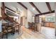 Spacious living area featuring exposed beams, wooden floors, and seamless flow from dining to kitchen at 510 Silhouette Way, Monument, CO 80132