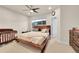 Cozy bedroom with a dark wooden bed frame, ceiling fan, and bright natural light at 6745 S Tempe Ct, Aurora, CO 80016
