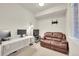 Efficient home office with a white desk, brown leather sofa, and natural light at 6745 S Tempe Ct, Aurora, CO 80016