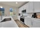 Bright kitchen featuring stainless steel appliances, white cabinets, and wood-look flooring at 6745 S Tempe Ct, Aurora, CO 80016