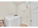 Functional laundry room with a white washer and dryer, and storage shelves at 6745 S Tempe Ct, Aurora, CO 80016