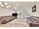 Spacious living room with hardwood floors, modern lighting, and comfortable brown leather sofas at 6745 S Tempe Ct, Aurora, CO 80016