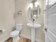 Cozy half bathroom featuring a pedestal sink, decorative mirror, and a modern design at 6745 S Tempe Ct, Aurora, CO 80016