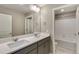 Bright bathroom featuring a double sink vanity with a quartz countertop and a shower and tub combo at 13486 Valentia St, Thornton, CO 80602