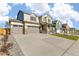 Street view of a modern home with a three-car garage, porch, and concrete driveway at 13486 Valentia St, Thornton, CO 80602