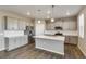 Modern kitchen features stainless steel appliances, gray cabinets, an island, and pendant lighting at 13486 Valentia St, Thornton, CO 80602