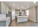 Well-lit kitchen boasts gray cabinets, stainless steel appliances, an island, and modern pendant lighting at 13486 Valentia St, Thornton, CO 80602