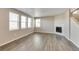 Large living room with hardwood floors, bright natural light, and a corner fireplace at 13486 Valentia St, Thornton, CO 80602
