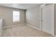 Neutral carpeted loft with window and white door offers versatile space at 13486 Valentia St, Thornton, CO 80602