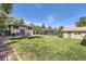 Large backyard with a well-maintained lawn, patio furniture, privacy fence, and storage shed at 3280 Fenton St, Wheat Ridge, CO 80212