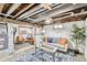 Finished basement featuring painted brick walls, exposed ceiling, and cozy seating area with stylish decor at 3280 Fenton St, Wheat Ridge, CO 80212