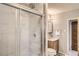 Bathroom featuring a glass-enclosed shower, wood vanity, and stylish wall paneling at 3280 Fenton St, Wheat Ridge, CO 80212