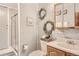 Bathroom with walk-in shower, wood vanity, and decorative accents on a gray wood paneled wall at 3280 Fenton St, Wheat Ridge, CO 80212