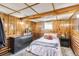 Cozy basement bedroom featuring wood paneled walls, ample storage space, and natural light from a small window at 3280 Fenton St, Wheat Ridge, CO 80212