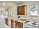 Open kitchen featuring wood cabinets, white appliances, and a pass-through window at 3280 Fenton St, Wheat Ridge, CO 80212