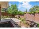 Landscaped backyard with a concrete patio, brick walls, garden beds, and privacy fencing at 2552 E Alameda Ave # 92, Denver, CO 80209