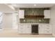 Basement bar with white cabinets, beverage fridge, modern backsplash, and wooden shelving at 2552 E Alameda Ave # 92, Denver, CO 80209