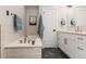 Elegant bathroom with a soaking tub, white cabinets, neutral tile, and brushed gold hardware at 2552 E Alameda Ave # 92, Denver, CO 80209