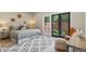 Sunlit bedroom featuring a queen size bed, modern rug, and access to a private outdoor area at 2552 E Alameda Ave # 92, Denver, CO 80209