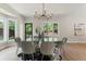 Dining room with a glass table, modern chandelier, and large windows offering natural light and backyard views at 2552 E Alameda Ave # 92, Denver, CO 80209