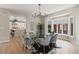 Open-concept dining room featuring a modern chandelier, glass table, and seamless access to the kitchen area at 2552 E Alameda Ave # 92, Denver, CO 80209