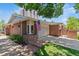 Brick home featuring an attached garage, American flag, and well-maintained front yard with mature trees at 2552 E Alameda Ave # 92, Denver, CO 80209