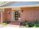 Close-up of the front door with brick facade, modern design, and landscaped entryway at 2552 E Alameda Ave # 92, Denver, CO 80209