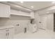 Bright laundry room with white cabinetry, a sink, and ample counter space at 2552 E Alameda Ave # 92, Denver, CO 80209