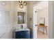 Stylish powder room with marble-look accent wall, blue vanity with gold accents and modern lighting fixtures at 2552 E Alameda Ave # 92, Denver, CO 80209