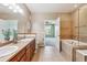 Comfortable bathroom boasts double vanity, large soaking tub, and access to bedroom at 11972 W Long Cir # 104, Littleton, CO 80127
