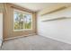 Well-lit bedroom offers neutral carpeting, a large sunny window, and shelving for storage at 11972 W Long Cir # 104, Littleton, CO 80127