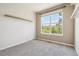 Bright bedroom boasts neutral carpeting, a large sunny window, and shelving for storage at 11972 W Long Cir # 104, Littleton, CO 80127
