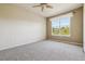 Spacious bedroom with soft carpeting, a ceiling fan, and a large window with natural light at 11972 W Long Cir # 104, Littleton, CO 80127