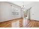 Bright dining room features wood floors, modern chandelier, and sliding door to a balcony overlooking lush landscaping at 11972 W Long Cir # 104, Littleton, CO 80127