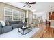 Bright living room features a ceiling fan, hardwood floors, and large window with natural light at 11972 W Long Cir # 104, Littleton, CO 80127