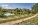 Picturesque pond with walking paths surrounded by lush greenery and reflections of nearby homes and trees at 11972 W Long Cir # 104, Littleton, CO 80127