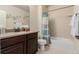 Bathroom featuring a tiled shower and tub, dark wood vanity, and neutral color scheme at 10653 E 163Rd Ct, Brighton, CO 80602